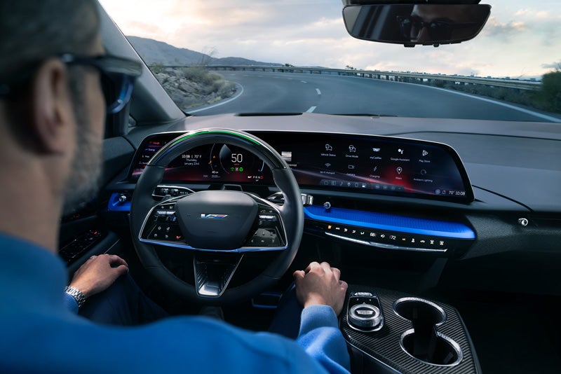 Front View of the 2026 OPTIQ-V Driving Through the Dusk Utilizing its Headlights | Cole Valley Cadillac in Warren OH